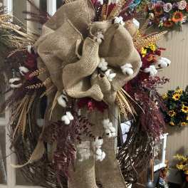 Rustic wreath with burlap bow, cotton bolls, and burgundy foliage
