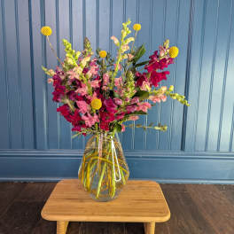Mixed pink and magenta flowers in a clear glass vase