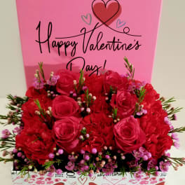 Pink Valentine’s Day gift box with red roses and a heart design