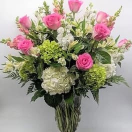 Pink roses and white hydrangeas in a clear glass vase