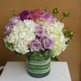 Lavender roses and white hydrangeas in a striped green vase
