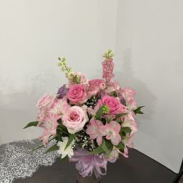 Pink rose bouquet with alstroemeria in a glass vase tied with ribbon