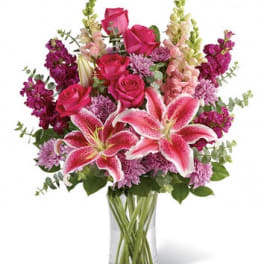 Pink lilies and roses in a clear glass vase