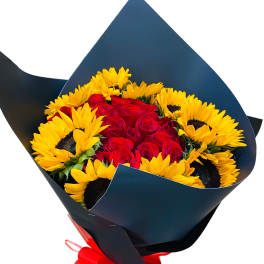 Bouquet of red roses and yellow sunflowers wrapped in dark paper with a red bow
