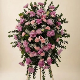 Pink and lavender funeral spray on a standing easel
