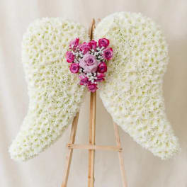 White floral angel wings with pink roses on a wooden easel
