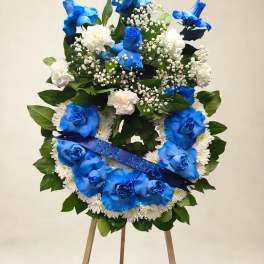 Blue and white floral wreath on an easel with a ribbon