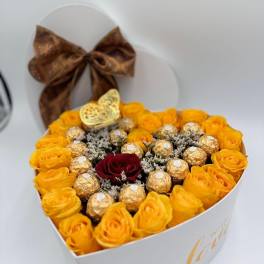 Heart-shaped white box with yellow roses, gold-wrapped chocolates, and a single red rose.