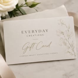 Floral gift card on a neutral surface with white flowers in the background