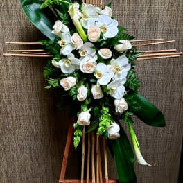 White orchids and roses arranged on a bamboo stand