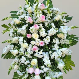 Large standing floral spray with white and pink roses and white daisies