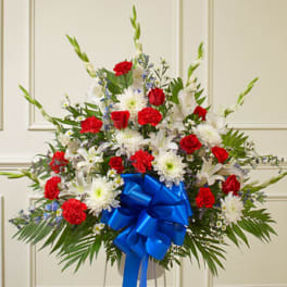 Large red and white floral arrangement with a blue ribbon bow