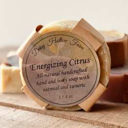 Round citrus soap bar with a paper label on a wooden surface