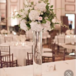 Tall white floral centerpiece in a clear glass vase