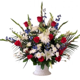 Red roses and white lilies in a white vase with blue and white flowers