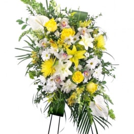 Standing floral spray with white and yellow flowers on an easel