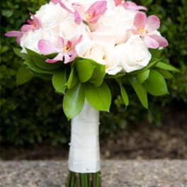White rose bouquet with pink orchids and green leaves