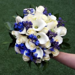 Bouquet of white calla lilies, white roses, and blue flowers