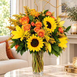 Sunflower and orange rose arrangement in a clear glass vase