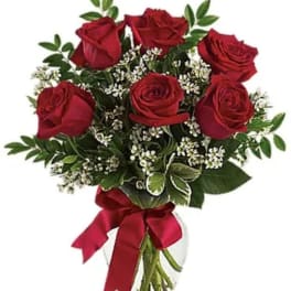 Bouquet of red roses with baby's breath in a clear glass vase