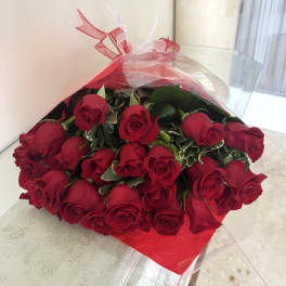 Wrapped bouquet of red roses with a red paper backing and clear cellophane