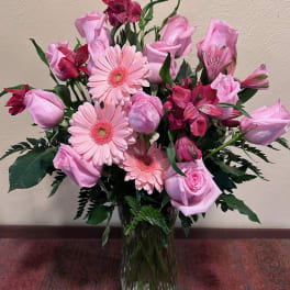 Pink roses, gerbera daisies, and alstroemeria in a glass vase