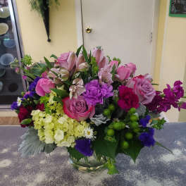 Pink and purple mixed bouquet in a clear glass vase