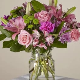 Pink and purple mixed bouquet in a clear glass vase