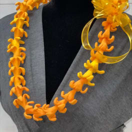 Bright orange artificial flower lei with a yellow ribbon bow on a black mannequin.