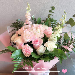 Pink and white bouquet with roses, hydrangea, and carnations in pink wrap