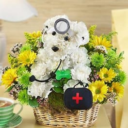 Teddy bear made of white flowers in a wicker basket with yellow daisies