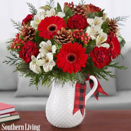 Red and white floral arrangement in a white textured pitcher vase