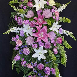 Standing floral spray with pink lilies, white lilies, and purple flowers