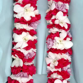 Flower lei made of red, white, and lavender blooms
