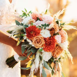 Bride holding a bouquet of peach, pink, and white flowers