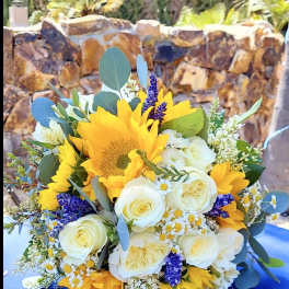 Bouquet of yellow sunflowers and white roses with purple accents