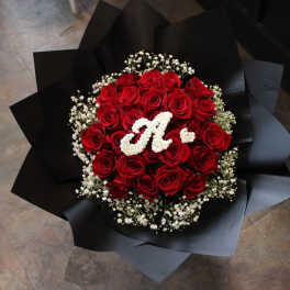 Bouquet of red roses with white baby's breath and a white monogram