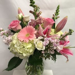 Mixed pink and white flowers arranged in a glass vase