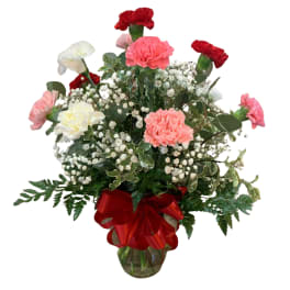 Bouquet of pink and red carnations with baby's breath in a glass vase
