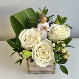 White roses in a wooden box with a small angel figurine