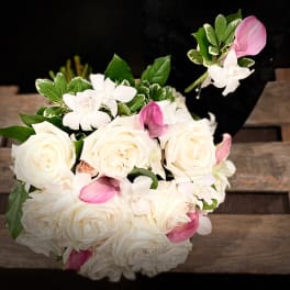 Bouquet of white roses and pink orchids with green foliage