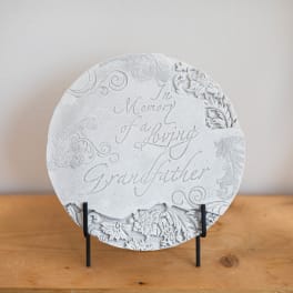 Round memorial plaque on a stand with engraved floral details