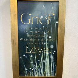Framed grief quote print with grass and dew on a dark background