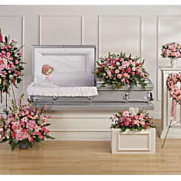 Pink floral funeral casket spray with matching standing arrangements and heart wreath