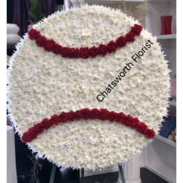 Large round floral tribute shaped like a baseball with red stitching