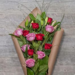 Bouquet of red and pink roses wrapped in brown paper