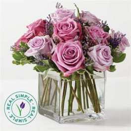 Pink and lavender roses in a clear square vase