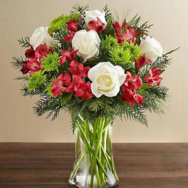 Bouquet of white roses and red flowers in a clear glass vase
