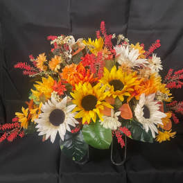 Autumn floral arrangement with sunflowers and white daisies on a black stand