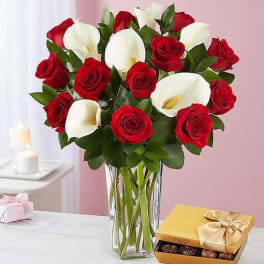 Bouquet of red roses and white calla lilies in a glass vase